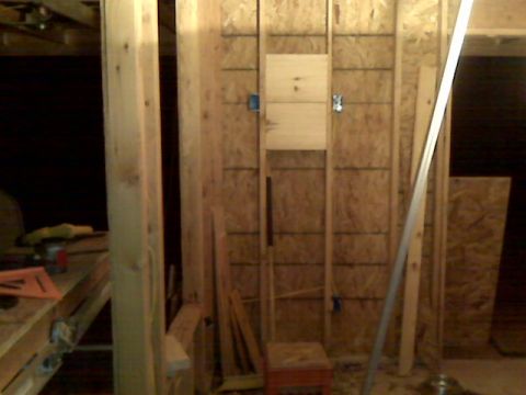 2005 Ford Mustang - This image shows an unfinished interior wall with exposed wooden studs and OSB sheathing. There are electrical boxes installed in the wall,…