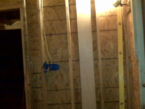 2005 Ford Mustang - This image shows the interior framing of a wall with electrical wiring and a blue electrical box. A yellow level is also visible against th…