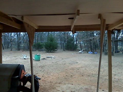 2005 Ford Mustang - The rear of a dark-colored vehicle, possibly a tractor attachment, is visible in the foreground. The scene appears to be an outdoor yard wi…