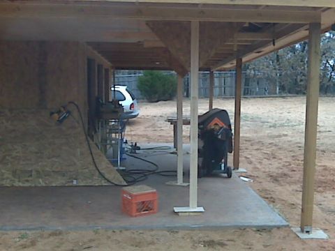 2005 Ford Mustang - A silver Ford Mustang is parked under a covered patio area that is under construction. Tools and building materials are visible around the…