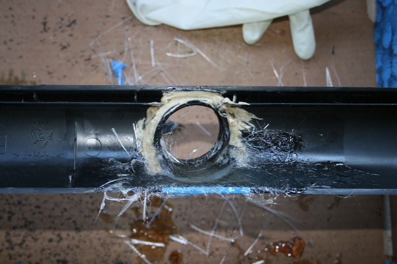 Black plastic duct with fiberglass and adhesive around a round port