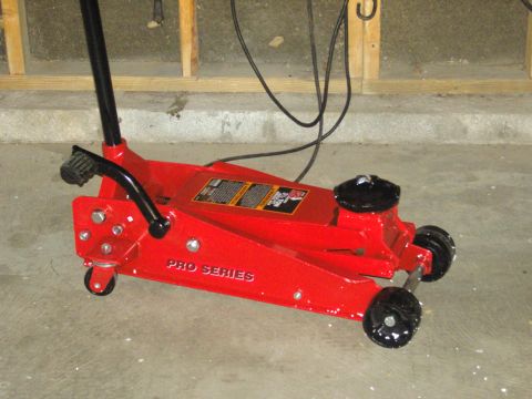 2007 Ford Mustang - Photograph of a red Pro Series hydraulic floor jack standing on a garage floor, not a document.