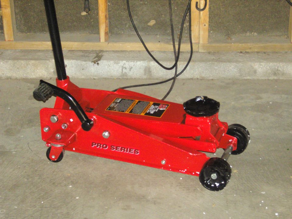 Photo of a red Pro Series hydraulic floor jack on a concrete floor