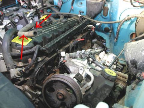 1995 Ford Bronco - A close-up view of the engine bay of a 1995 Ford Bronco, focusing on the valve cover and various hoses and connectors.