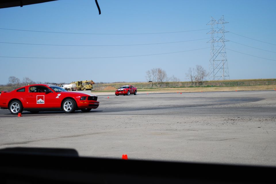 Red Ford Mustang with Marlboro livery on track, number 2 visible. 2005 model