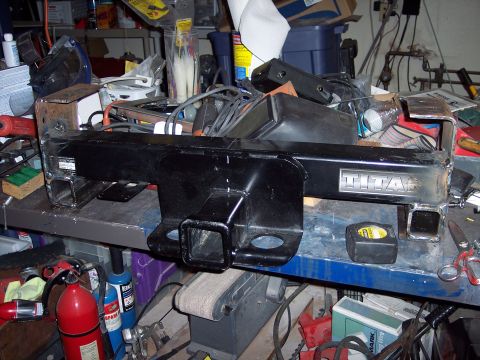 1981 Kenworth W900A - Titan trailer hitch receiver shown on a cluttered workbench with various tools and supplies.