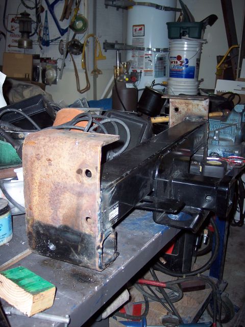 1981 Kenworth W900A - A close-up of a truck frame part, showing wear and tear, resting on a cluttered workbench.