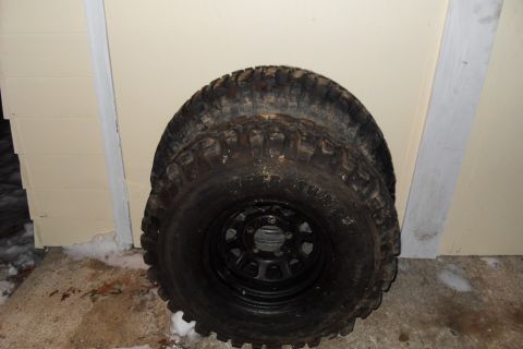 1980 Dodge Magnum - A pair of off-road tires are shown stacked together, leaning against a light-colored wall with snow on the ground.
