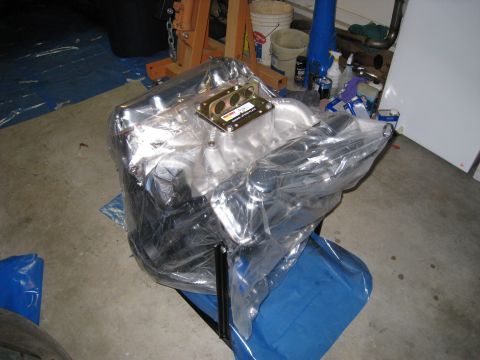 1979 Ford Bronco - Engine covered in plastic wrap, likely new or in storage, in a garage setting.