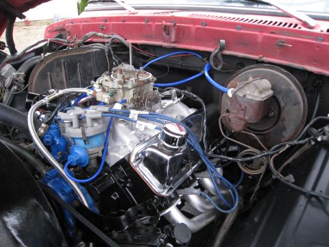1979 Ford Bronco - The engine bay shows a V8 engine with a carburetor and blue spark plug wires.