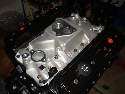 1984 Jeep J-10 - Close-up view of an engine's intake manifold and valve covers, with an oil cap indicating fluid levels.