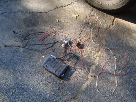 1984 Jeep J-10 - Car stereo and wiring harness on the ground, possibly removed from a vehicle.