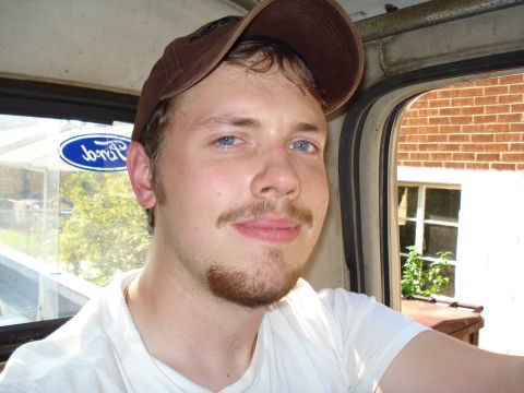 1991 Ford Bronco - A man with blue eyes and a mustache is seen inside a vehicle, with a Ford logo on the window.