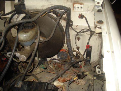 1991 Ford Bronco - Close-up of the engine bay wiring and brake booster, showing complex connections.