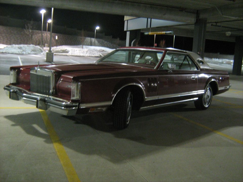Maroon Lincoln Continental Mark VII parked at night in a parking garage