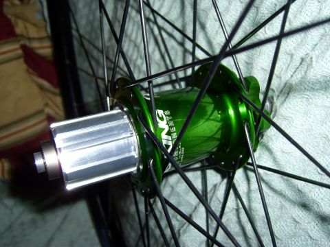 1972 Ford Ranchero - Close-up of a green bicycle wheel hub, showing the cassette body and spokes against a textured background.