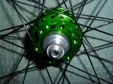1972 Ford Ranchero - Close-up of a green bicycle hub with silver accents and numerous black spokes against a textured background.
