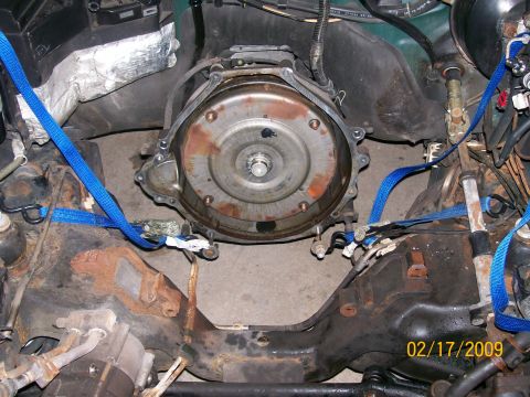 1995 Mercury Grand Marquis - Underside view of a V8 engine bellhousing area with the transmission removed, exposing the flexplate and torque converter studs inside the…