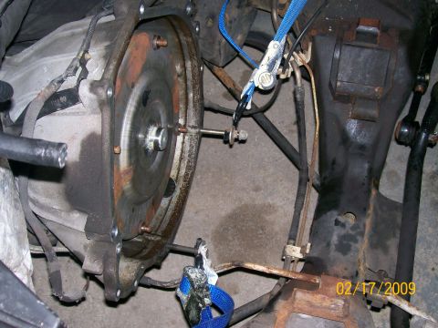 1995 Mercury Grand Marquis - Underside view of an exposed transmission bellhousing and flywheel with ratchet straps, dated 02-17-2009.