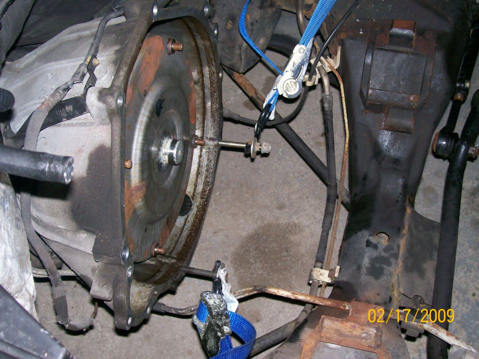 Transmission bellhousing and flywheel exposed under a vehicle