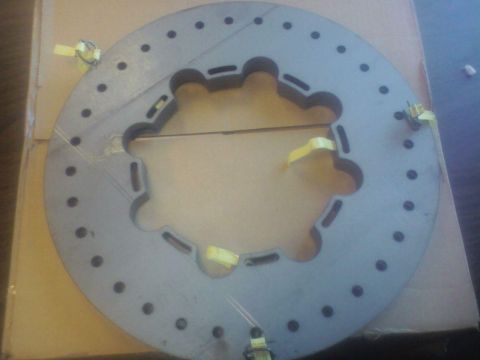 1992 Ford F-350 - A single brake rotor is shown, secured with yellow straps to a cardboard box, indicating it is a replacement part.