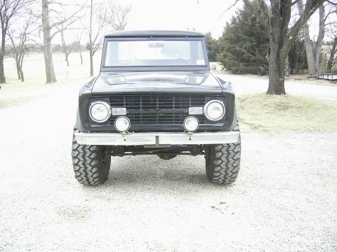 1978 Ford Bronco - This classic SUV is parked on a gravel driveway with trees in the background.