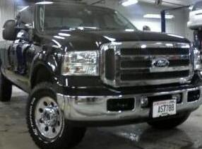 1994 Ford F-250 - This black Ford truck is parked inside a garage with its front end facing the camera.