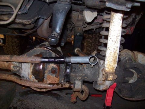 1986 Ford Bronco - Undercarriage view of suspension and steering components, including a shock absorber and tie rod assembly.