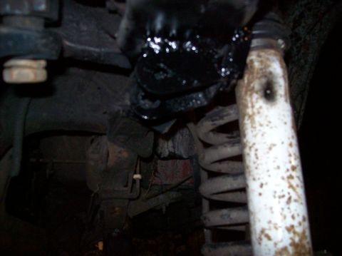 1986 Ford Bronco - Greasy suspension part and coil spring visible in the image.