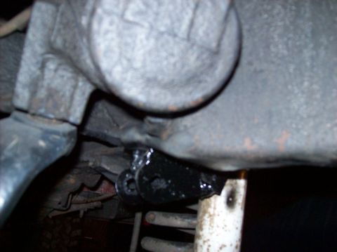 1986 Ford Bronco - A close-up view of a vehicle's undercarriage, focusing on a suspension part and a coil spring.
