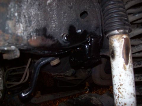 1986 Ford Bronco - Close-up view of a vehicle's undercarriage, showing mechanical components and suspension parts.
