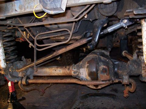 1986 Ford Bronco - Undercarriage view of a 1986 Ford Bronco, showing the front axle and suspension.
