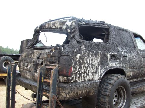 1986 Ford Bronco - This heavily damaged SUV is covered in mud and appears to be on a trailer.