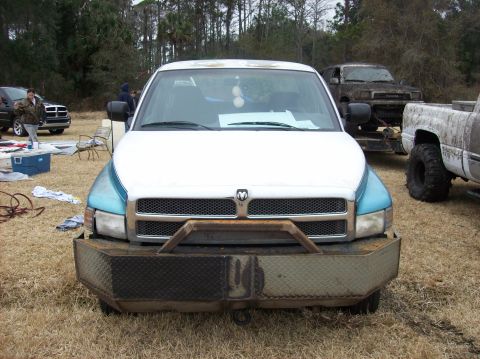 1986 Ford Bronco - A modified Dodge Ram pickup truck is parked outdoors with other vehicles nearby.