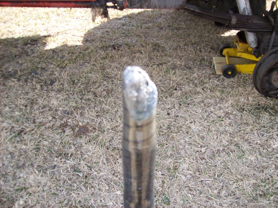 Close-up of a vehicle suspension part with a yellow jack visible