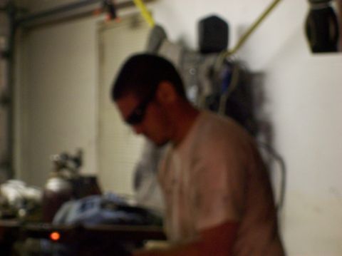 1986 Ford Bronco - A person is seen working in a garage environment with various tools and equipment visible.