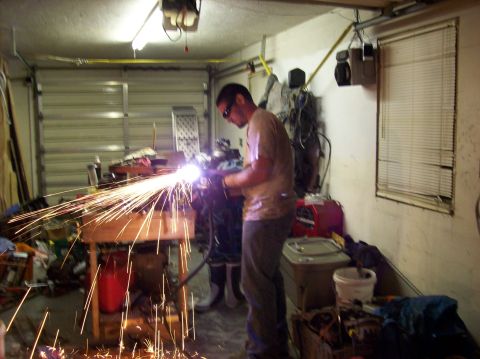 1986 Ford Bronco - A person is welding in a garage, creating a shower of sparks.