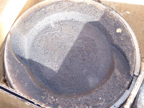 1995 Ford Bronco - A close-up view of a damaged piston, showing signs of wear and a crack.