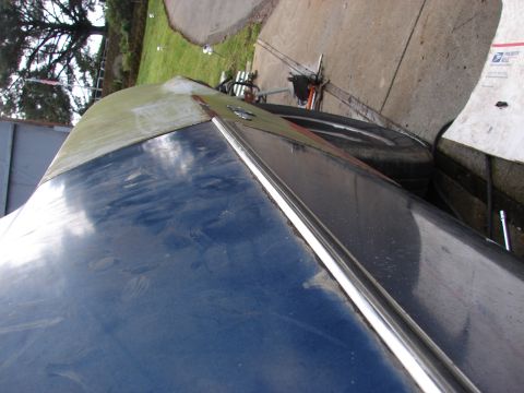 1973 Ford Ranchero - Detail of a car's body panel, showing blue paint and a chrome accent strip.
