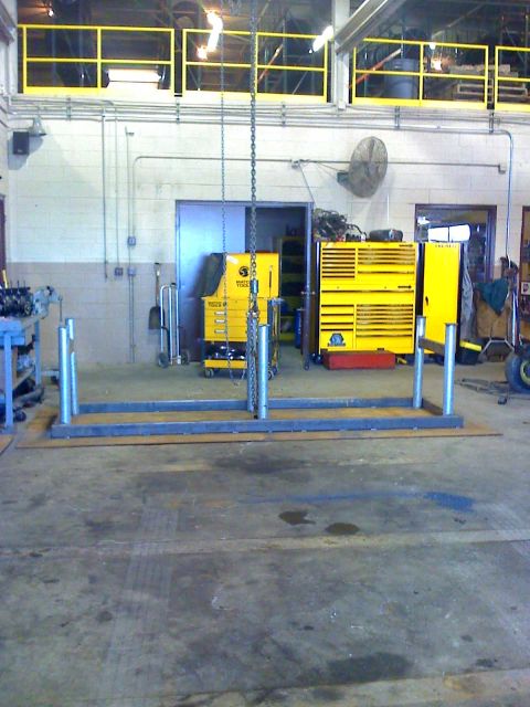 1992 Ford Bronco - A workshop scene displays various tools and equipment, including large yellow tool chests and a metal fabrication frame.