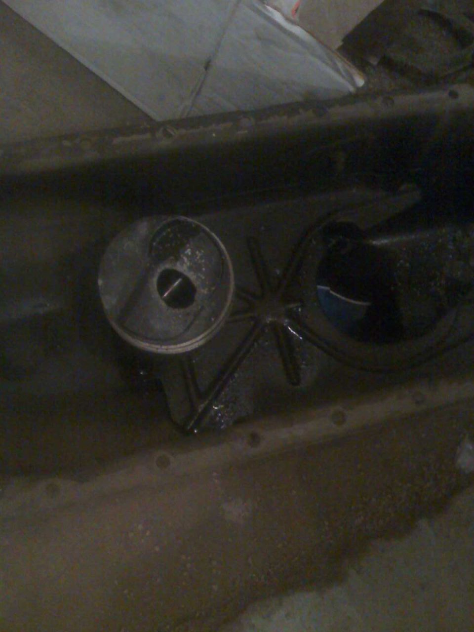 Oil pan with filter housing removed, showing internal star-shaped pickup screen