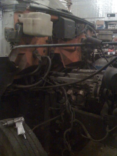 1992 Ford Bronco - A close-up view of a truck's engine bay, showing various hoses, wires, and mechanical parts.