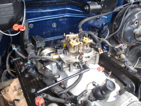 1984 Jeep J-10 - Close-up view of an engine bay, focusing on the carburetor and associated components.