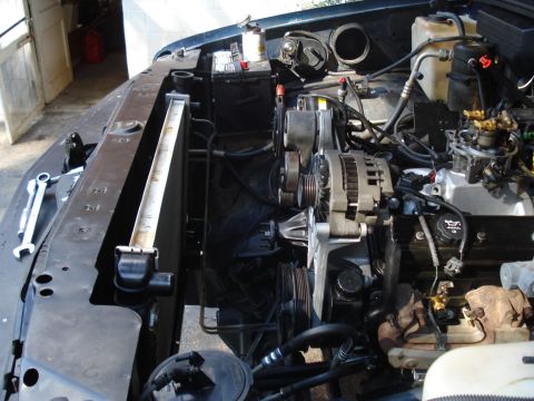 1984 Jeep J-10 - The engine bay of a vehicle is shown with various mechanical parts and a radiator.