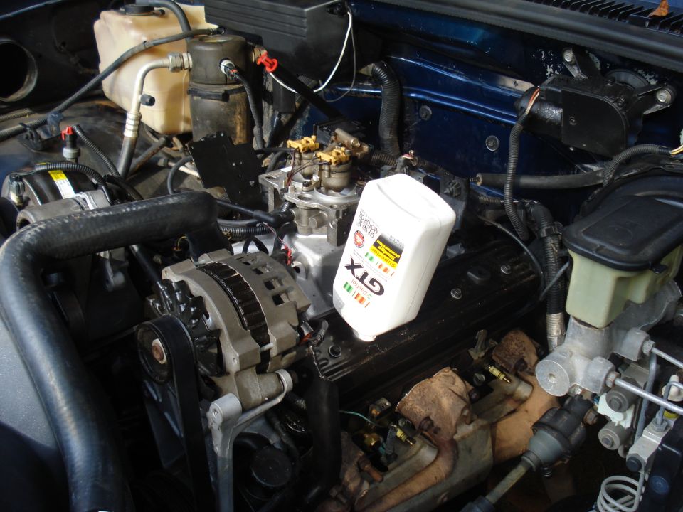 Engine bay with a bottle of GTX oil on the valve cover