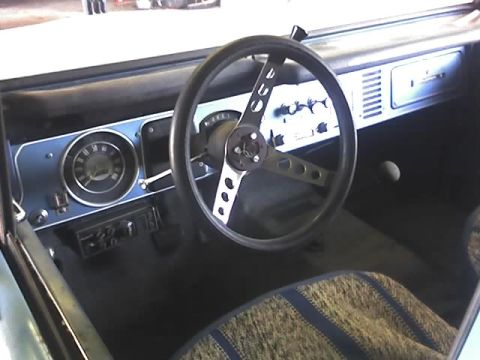 1996 Ford Bronco - Interior view of a 1966 Ford Bronco, a custom steering wheel and aftermarket radio.