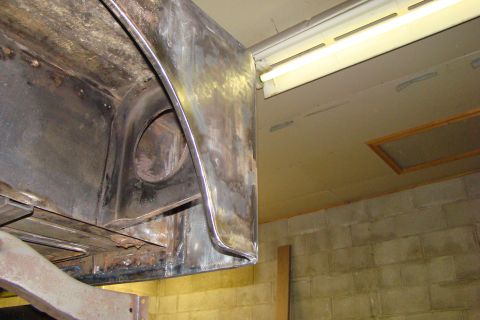 1948 Jeep Wrangler - Close-up view of a bare metal vehicle body panel, likely undergoing repair or restoration.