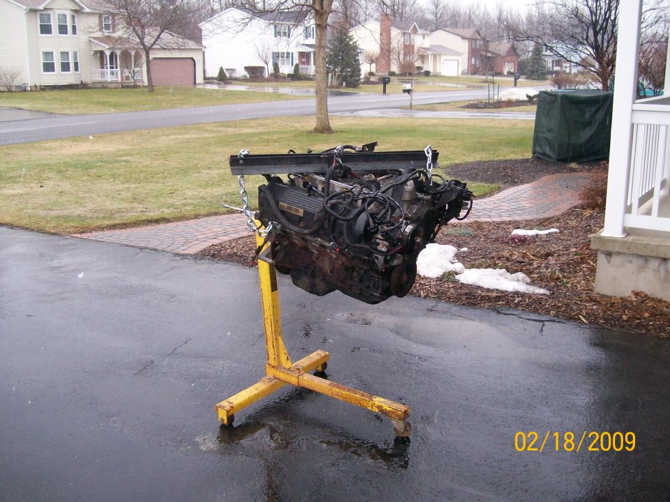Engine on a yellow stand, outside a house. Date stamp says 02/18/2009