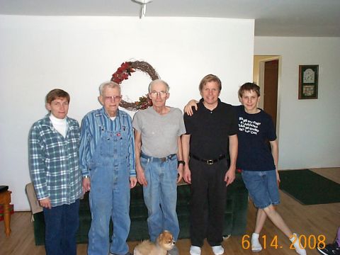 1984 Ford Mustang - A group of five people and a small dog are gathered indoors, posing for a photograph in front of a wall decorated with a wreath.