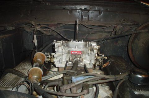1979 Ford Bronco - The engine bay features an Edelbrock carburetor and visible fuel filters, with wiring and engine components surrounding it.